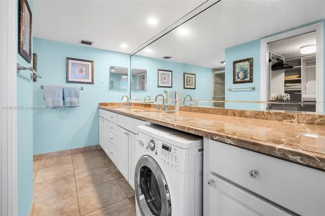 a utility room with granite countertop cabinets and washer