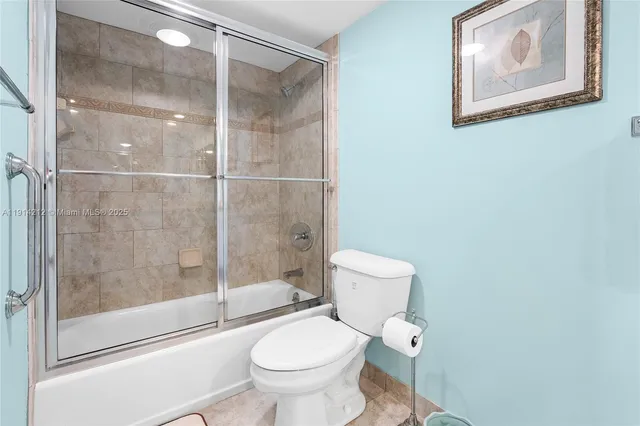 a white toilet sitting next to a shower