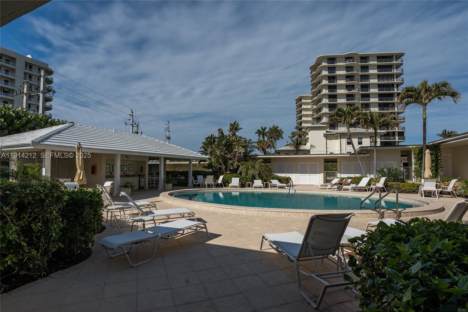 350 South Beach Road, Unit 204 Tequesta, FL 33469 - Photo 31 of 38 a view of a patio with table and chairs potted plants and a large tree