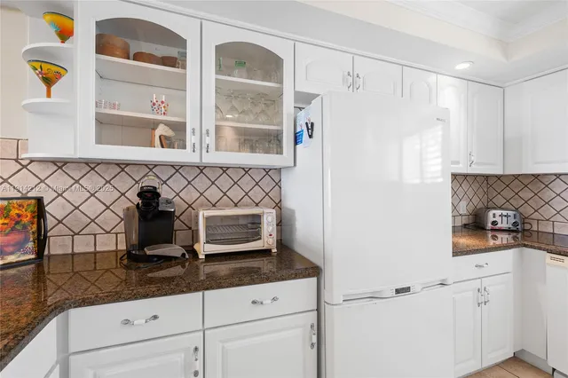 a kitchen with granite countertop a sink a stove and a refrigerator