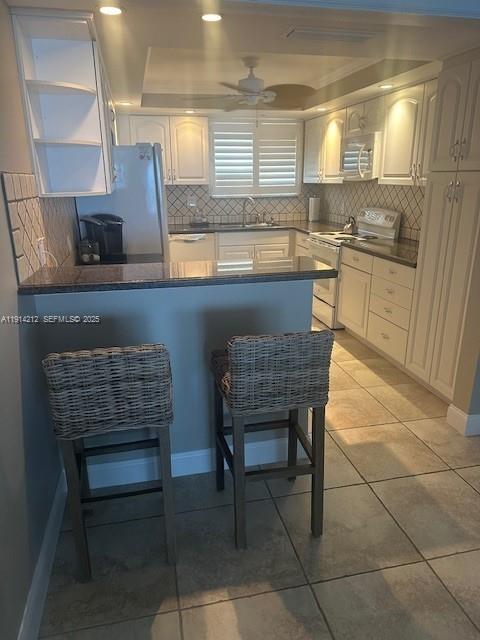 350 South Beach Road, Unit 204 Tequesta, FL 33469 - Photo 8 of 36 a kitchen with a sink a kitchen island a stove and a refrigerator