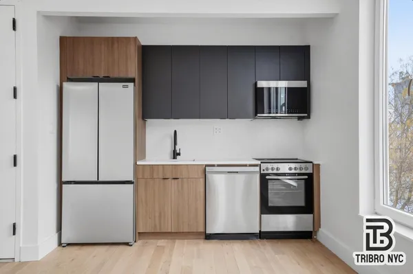 a kitchen with a refrigerator sink and cabinets