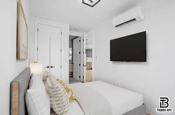 a bedroom with a bed and a flat screen tv
