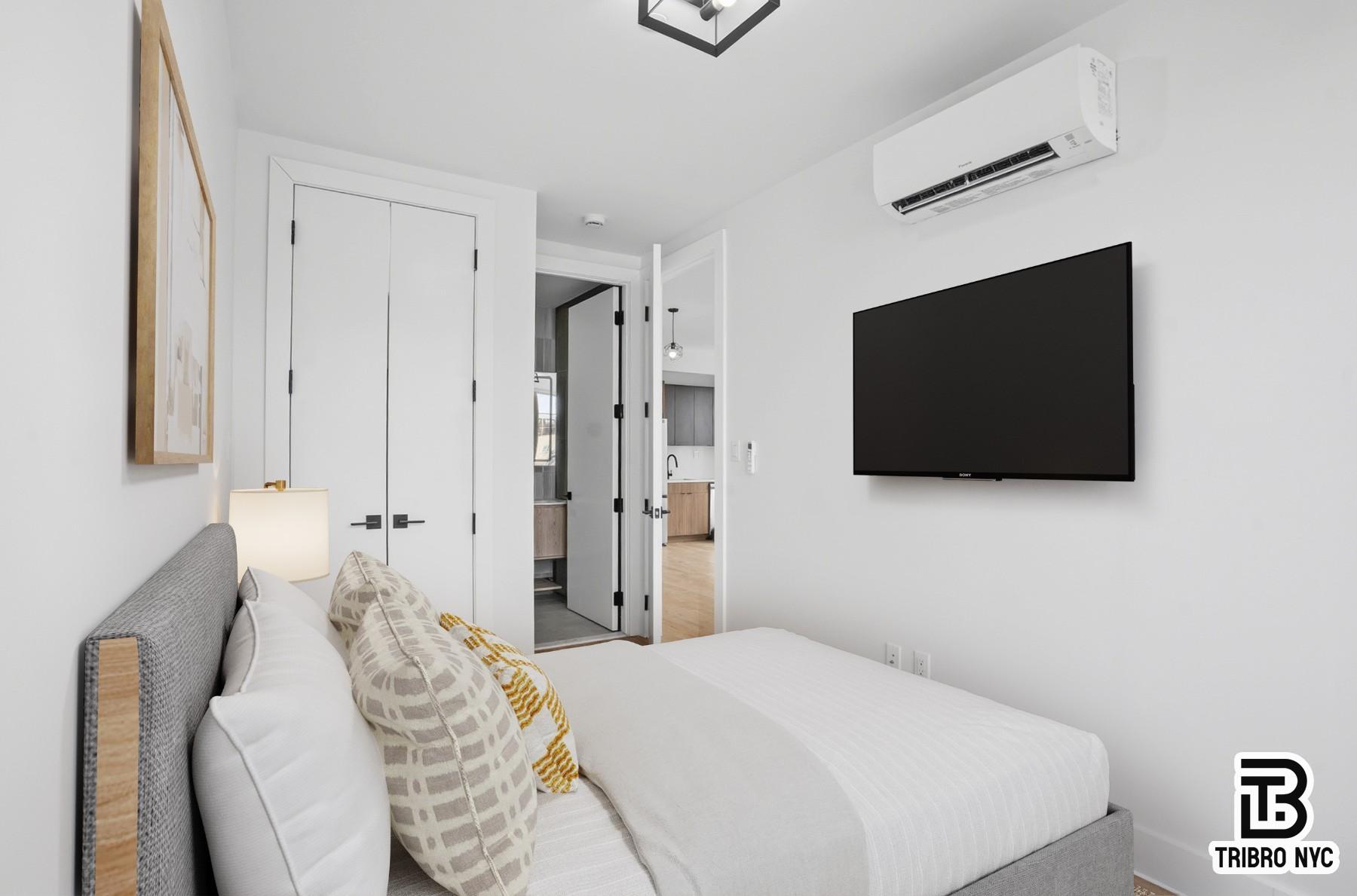 96 Moore Street, Unit 2R Brooklyn, NY 11206 - Photo 6 of 8 a bedroom with a bed and a flat screen tv