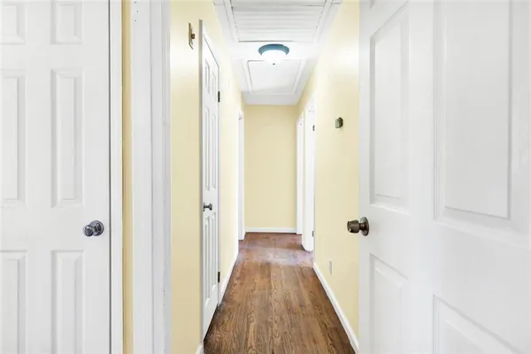 a view of a hallway with wooden floor and a shower