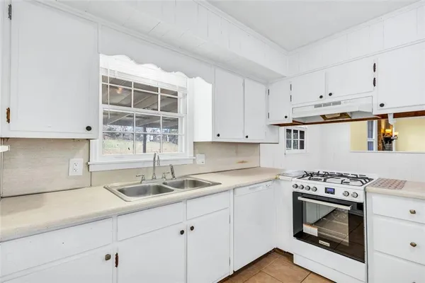a kitchen with cabinets appliances a sink and a counter top