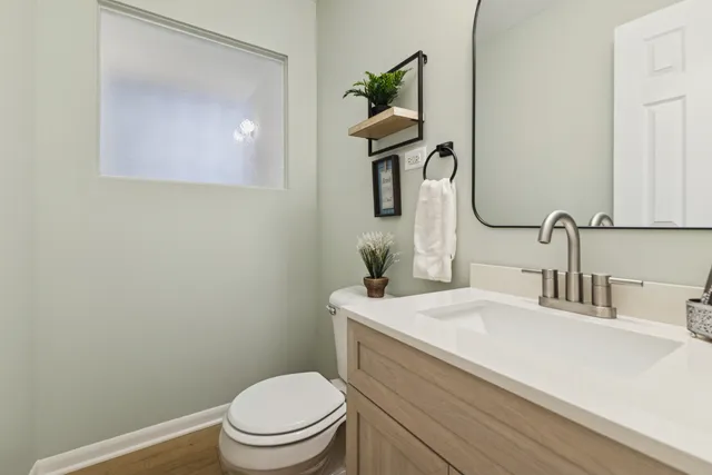 a bathroom with a toilet a sink and mirror