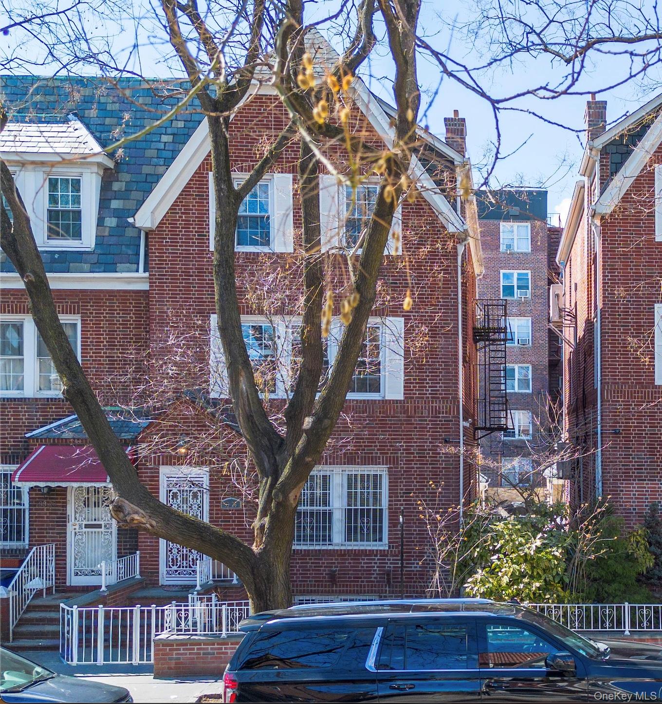 a view of a brick house with a large tree