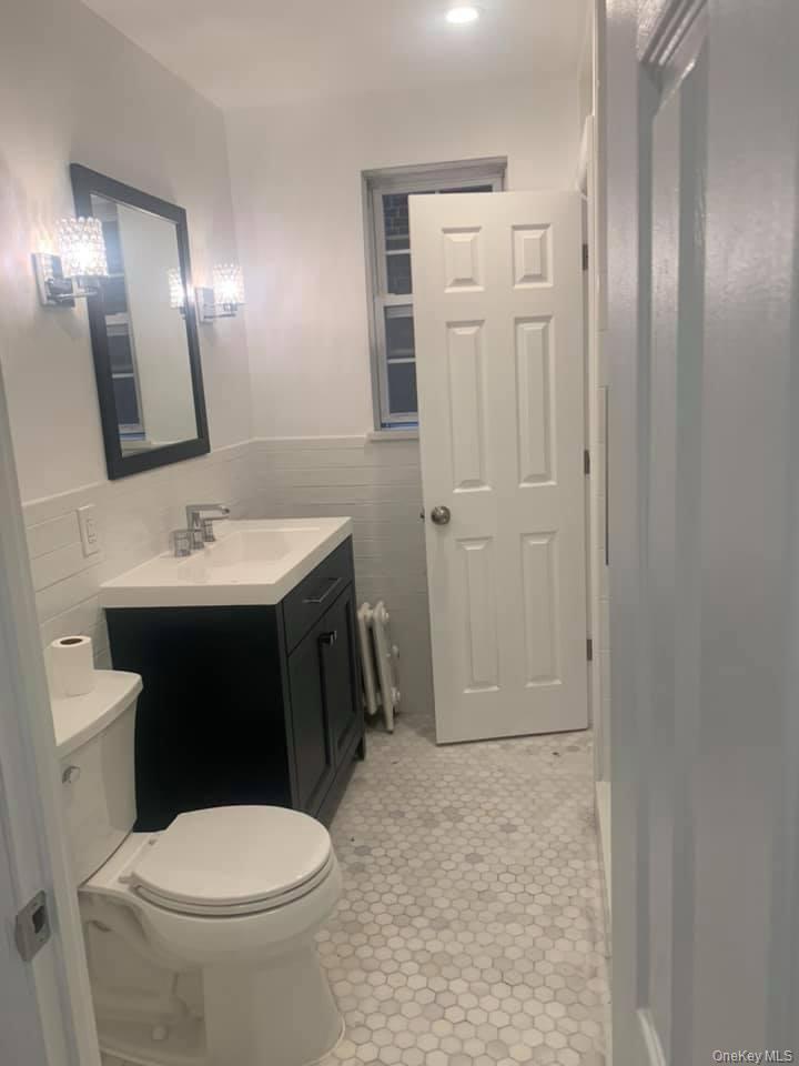 33-26 83rd Street Queens, NY 11372 - Photo 11 of 18 a bathroom with a sink a toilet and mirror