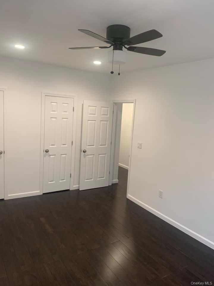 33-26 83rd Street Queens, NY 11372 - Photo 9 of 18 an empty room with wooden floor ceiling fan and windows