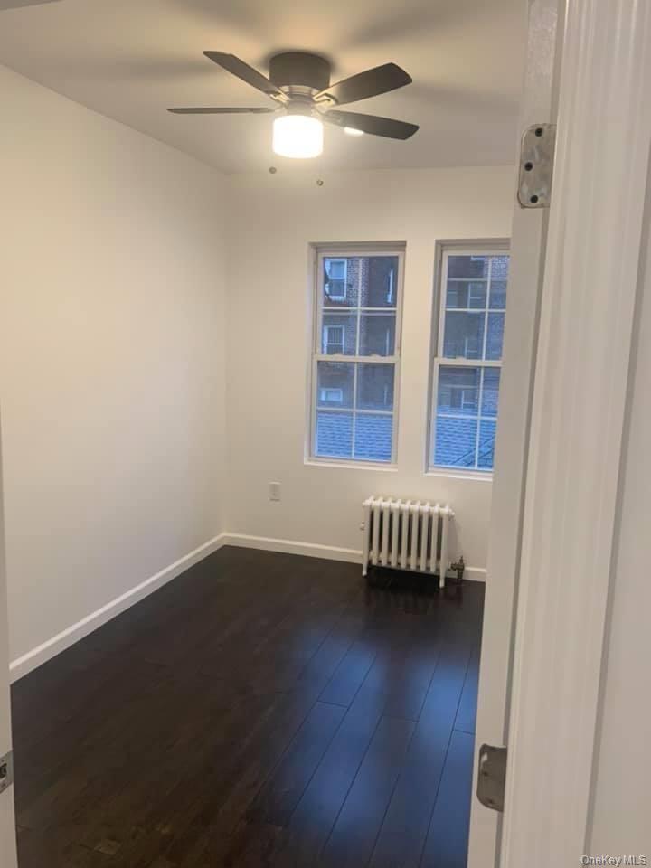 33-26 83rd Street Queens, NY 11372 - Photo 10 of 18 a view of an empty room with wooden floor and a window