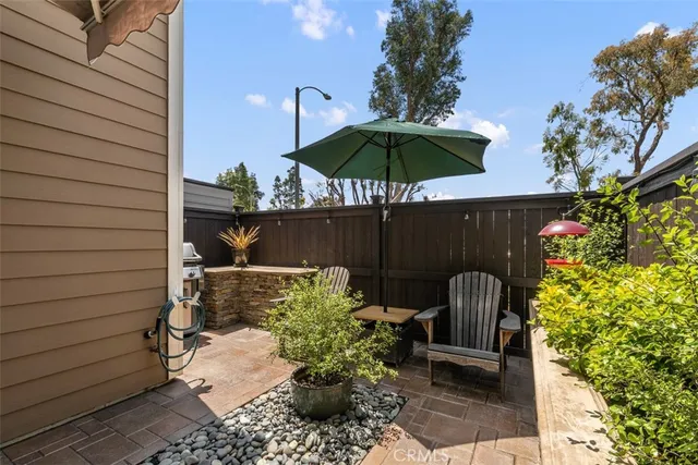 a view of a chair and table under an umbrella in patio