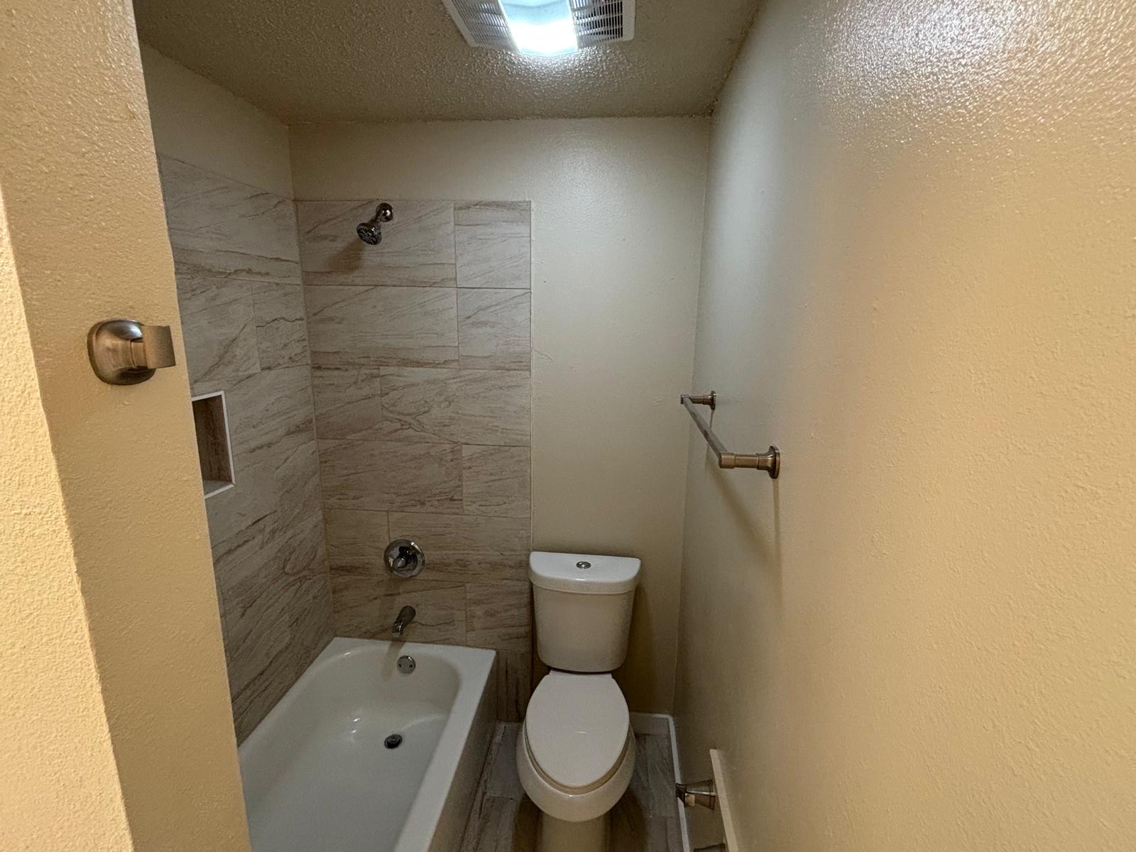 4609 East 12th Street, Unit 4 Austin, TX 78721 - Photo 13 of 14 A classic bathtub and tile surround define this functional bathroom space.