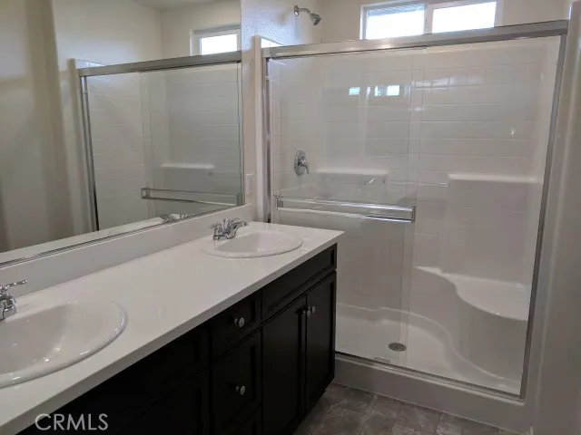 a bathroom with a shower sink vanity and mirror