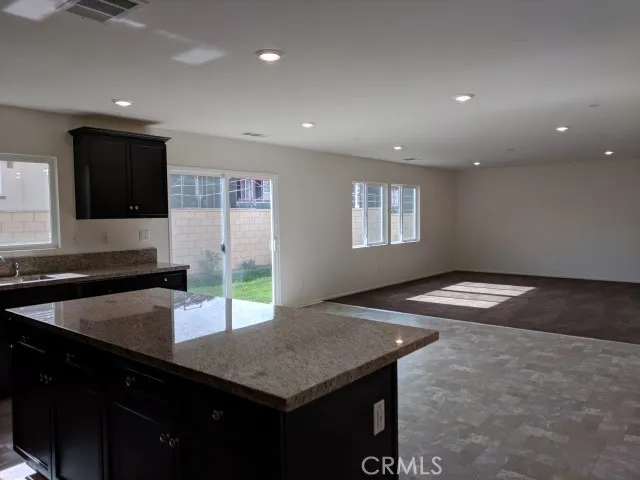a kitchen with a sink dishwasher and a refrigerator with wooden floor