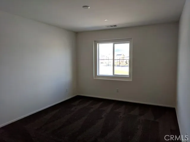 an empty room with wooden floor and a window