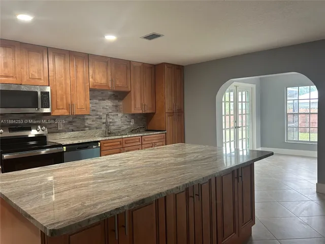 a kitchen with stainless steel appliances wooden cabinets a stove and a sink