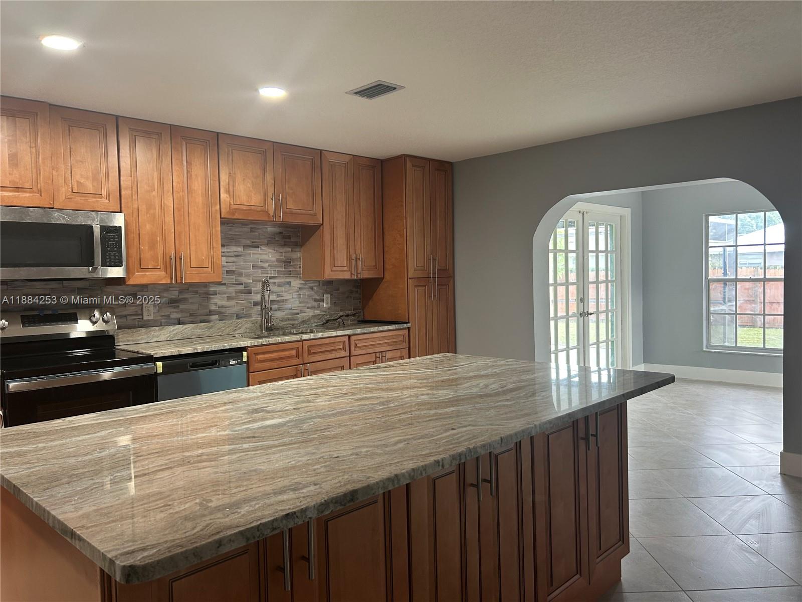 7109 Santa Rosa Parkway Fort Pierce, FL 34951 - Photo 2 of 11 a kitchen with stainless steel appliances wooden cabinets a stove and a sink