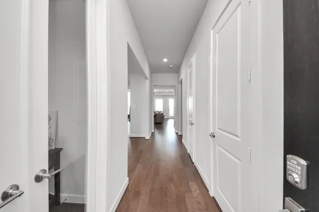 a view of a hallway with wooden floor and closet