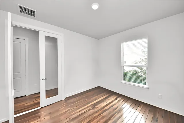 an empty room with a window and a fan