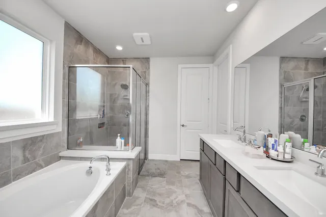 a bathroom with a double vanity sink mirror and shower