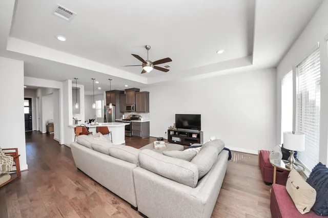 a living room with furniture and a large window with wooden floor