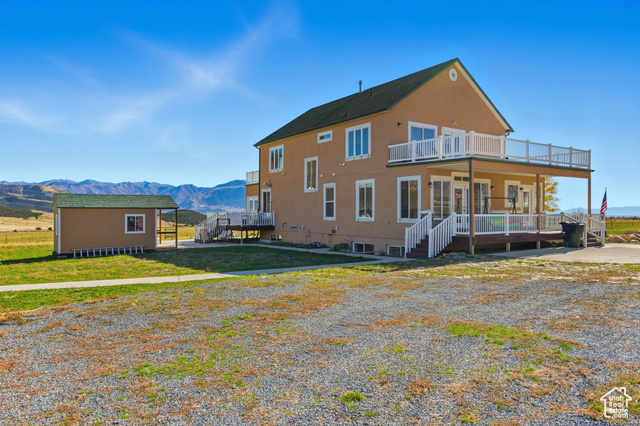 4768 East Hickman Canyon Road Stockton, UT 84071 - Photo 62 of 85 North side of home featuring a mountain view, deck, and a out building.