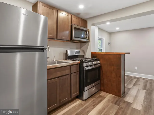 a kitchen with stainless steel appliances granite countertop a refrigerator a stove top oven a sink and dishwasher