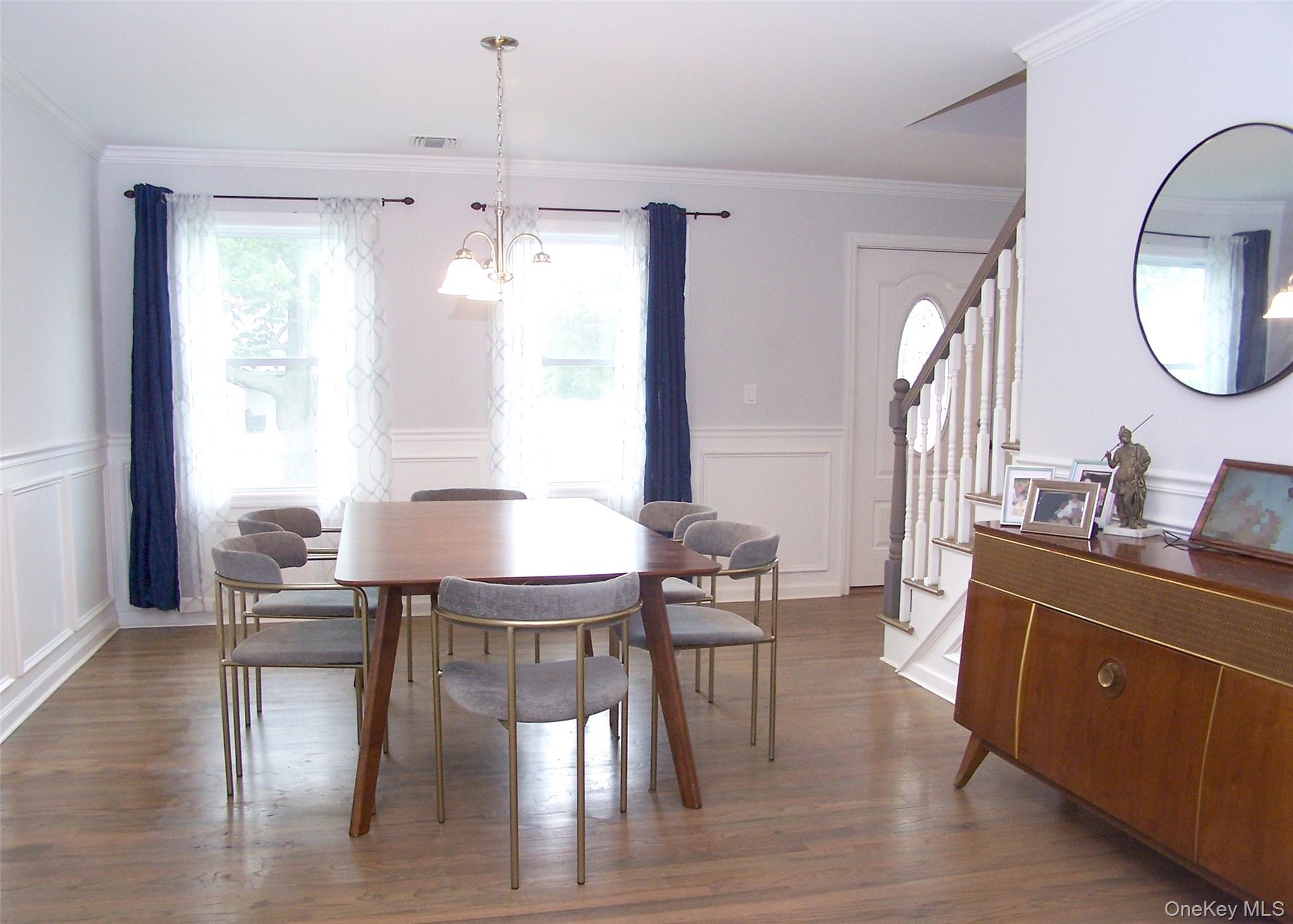 8 Narcissus Road Mastic Beach, NY 11951 - Photo 4 of 20 a dining room with wooden floor a chandelier a wooden table and chairs