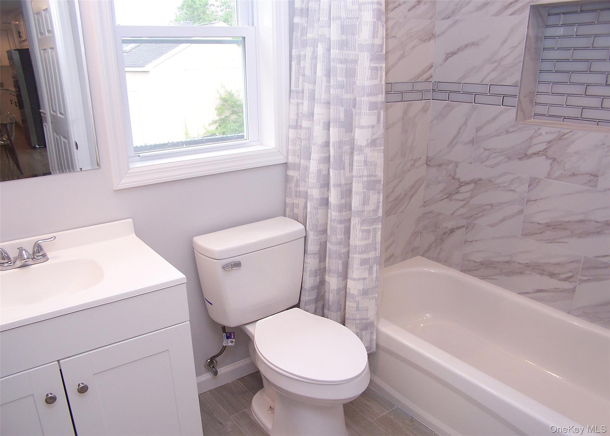 8 Narcissus Road Mastic Beach, NY 11951 - Photo 8 of 20 a bathroom with a sink toilet and bathtub