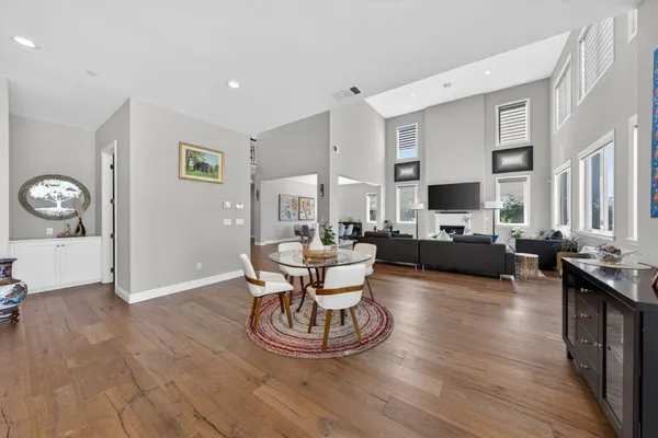 a kitchen with kitchen island granite countertop a sink a stove and chairs