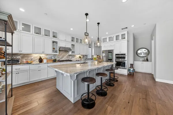 a open kitchen with stainless steel appliances granite countertop a lot of counter space and wooden floors