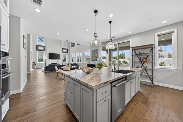 a kitchen with stainless steel appliances a dining table chairs stove and cabinets