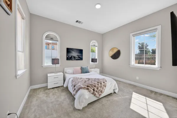 a spacious bedroom with a bed and a large window