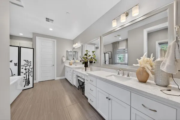 a bathroom with a granite countertop sink mirror bathtub and shower