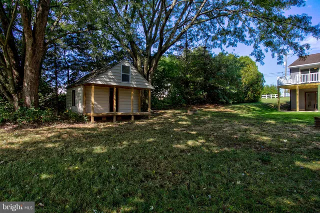 a view of a small house with a yard