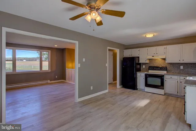 a kitchen with granite countertop a refrigerator a stove a sink and a microwave oven