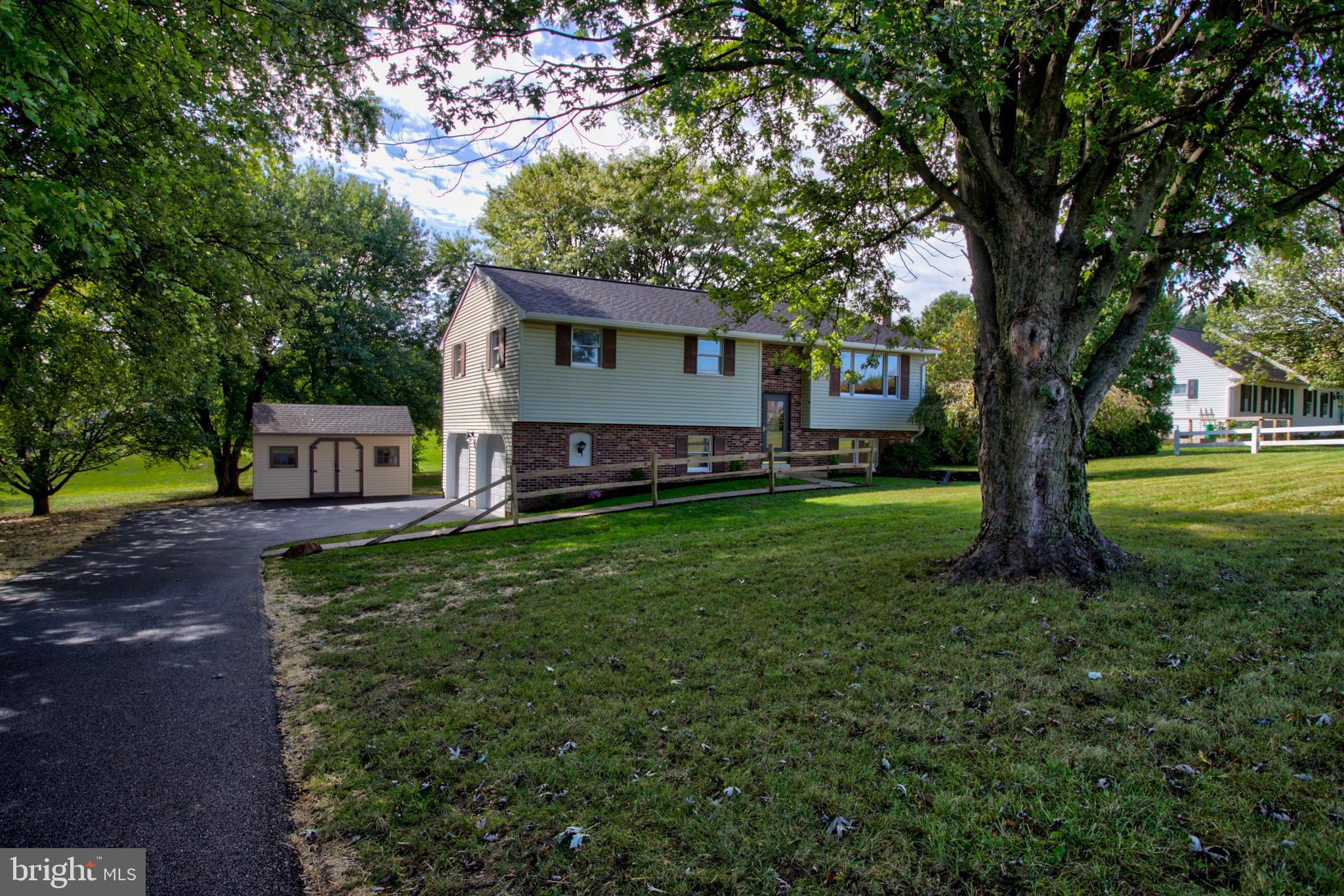 2891 Newport Road Manheim, PA 17545 - Photo 40 of 56 a front view of a house with a garden and trees