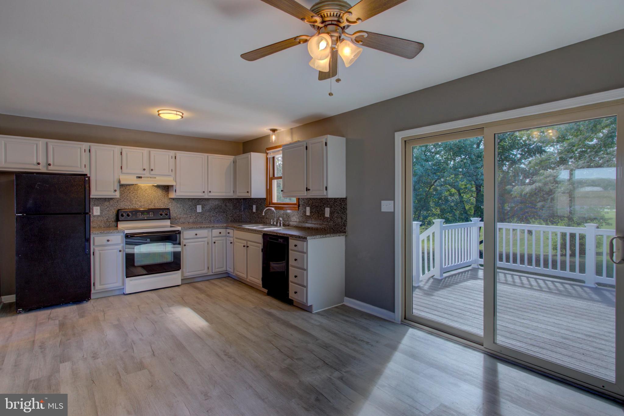2891 Newport Road Manheim, PA 17545 - Photo 4 of 56 a kitchen with granite countertop a refrigerator a stove a sink and a microwave oven
