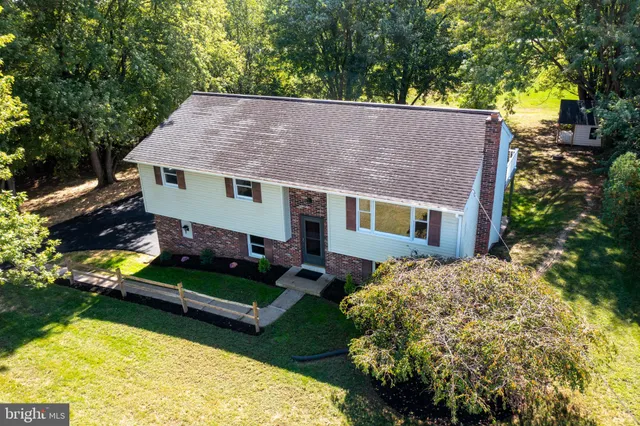 an aerial view of a house with a garden and lake view