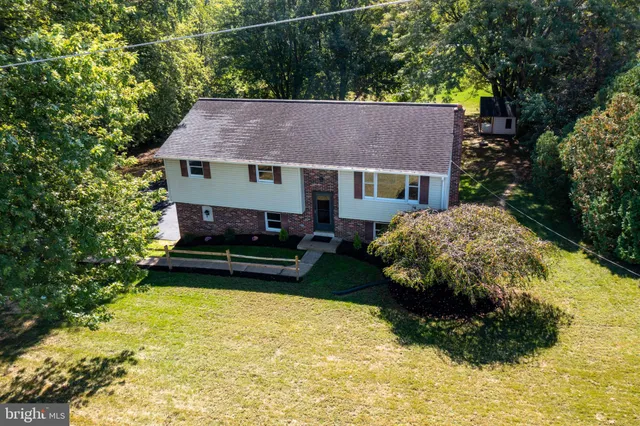 an aerial view of a house with plants and large trees