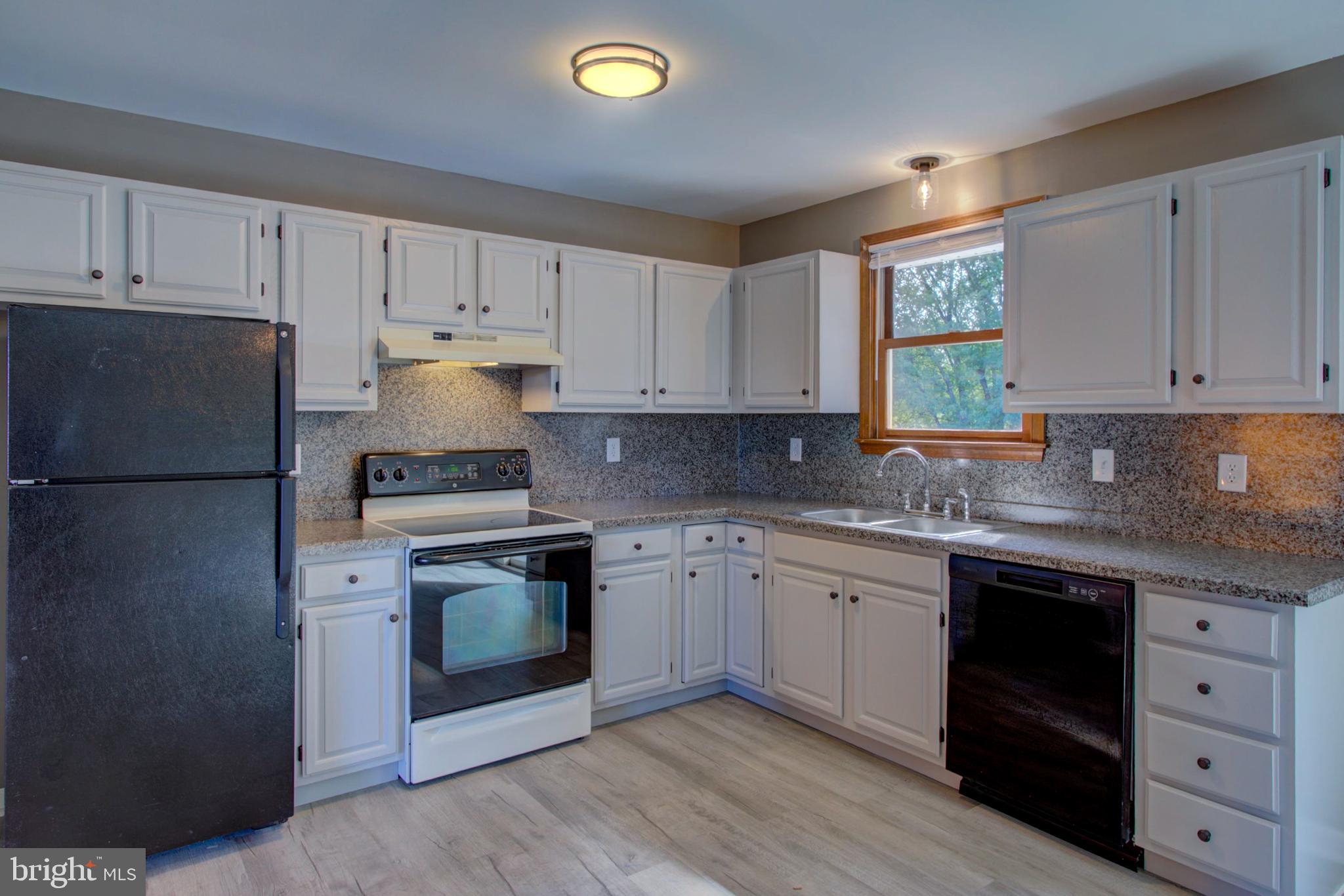2891 Newport Road Manheim, PA 17545 - Photo 7 of 56 a kitchen with granite countertop white cabinets and white appliances