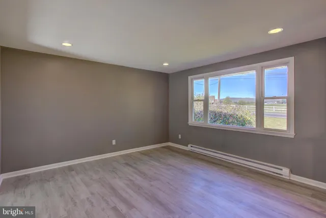 a view of a hallway with wooden floor and windows