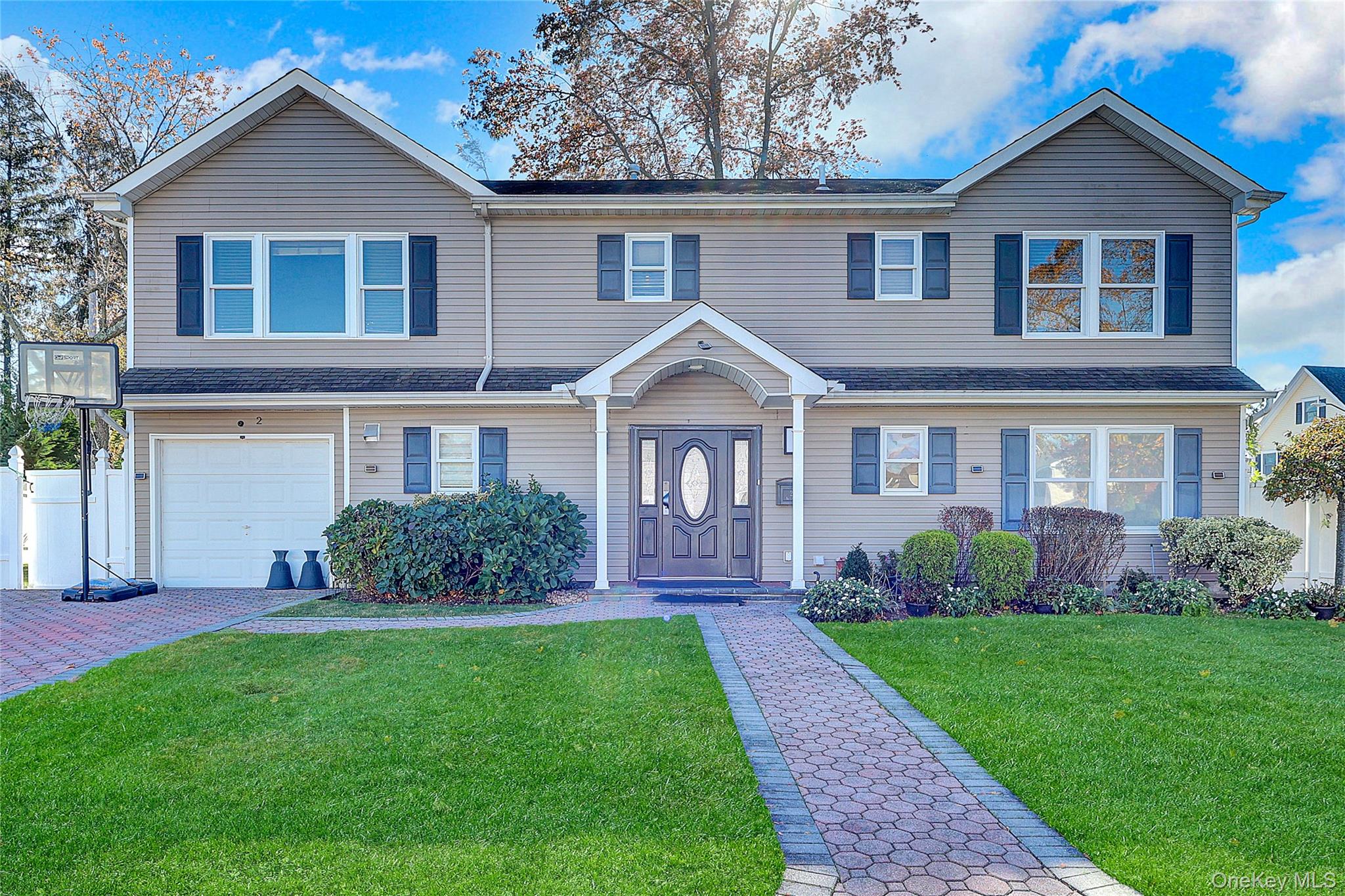 a front view of a house with a yard and green space