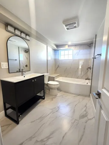 a bathroom with a toilet sink and mirror