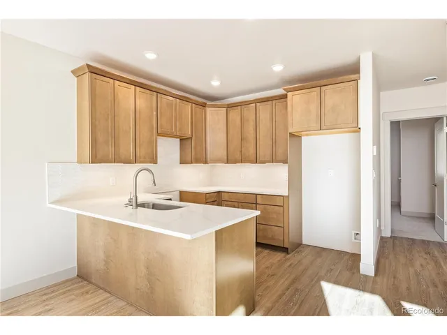 a kitchen with a sink a stove a refrigerator a center island and cabinets