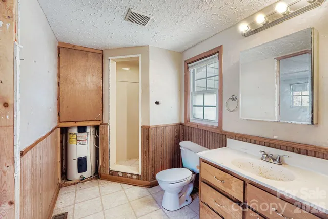 a bathroom with a granite countertop toilet sink and mirror