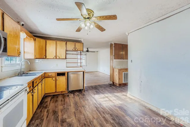 a kitchen with stainless steel appliances a stove cabinets and wooden floor