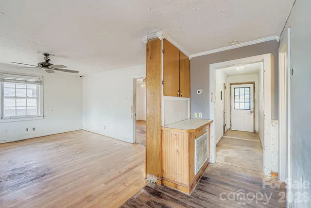 an empty room with wooden floor and a bathroom