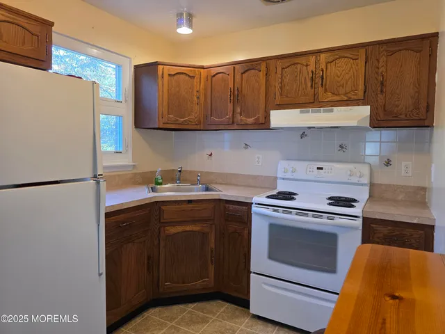 a kitchen with a stove top oven sink and cabinets